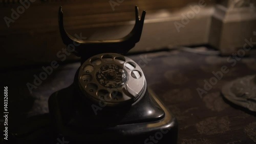 Rotary style telephone dialing numbers. Man answer old telephone headset. Old style Retro Black Antique Rotary telephone. World War II style telephone used for military communications.