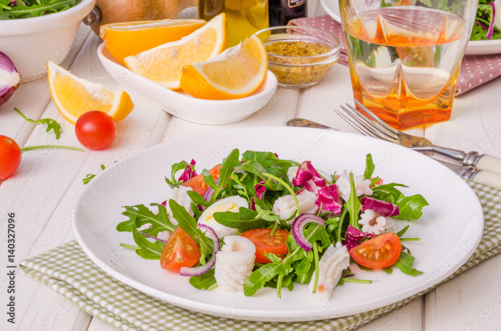 Salad with arugula, squid, cherry tomatoes, onion and quail eggs Salad with arugula, squid, cherry tomatoes, onion and quail eggs