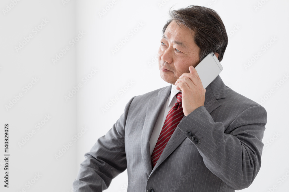 携帯電話で通話するビジネスマン、中年男性