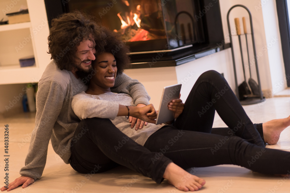 Obraz premium multiethnic couple using tablet computer on the floor