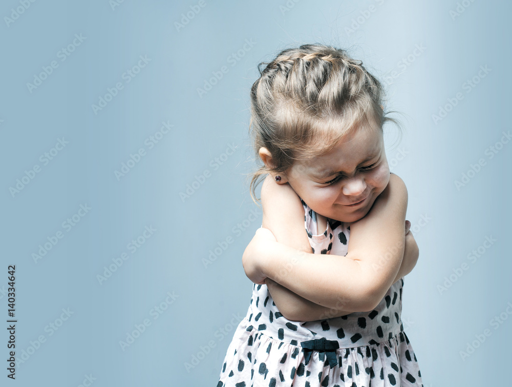 Portrait of a little girl. She is crying and hurt