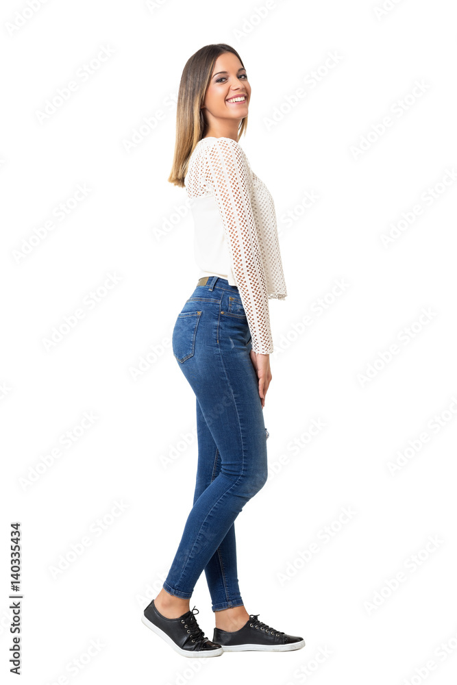 Charming woman in braided shirt and jeans laughing at camera. Side view.  Full body length portrait isolated over white background. Photos | Adobe  Stock