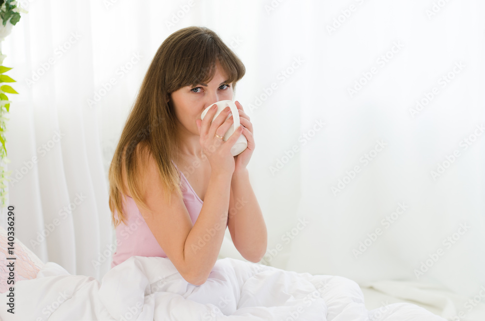 Beautiful woman is drinking tea in bed Beautiful woman is drinking tea in bed