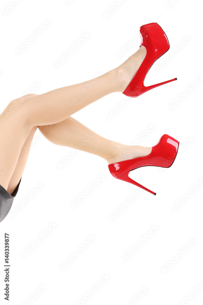 Female legs with red high heels on a white background Female legs with red high heels on a white background