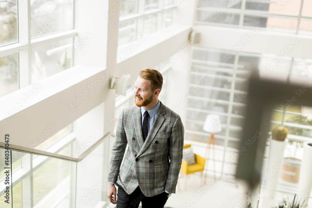 Young businessman going up the stairs in the office building Young businessman going up the stairs in the office building