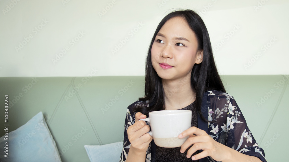 Asia woman holding cup of coffee and smiling Asia woman holding cup of coffee and smiling