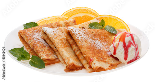 Serving pancakes with ice cream and orange slices on the plate.