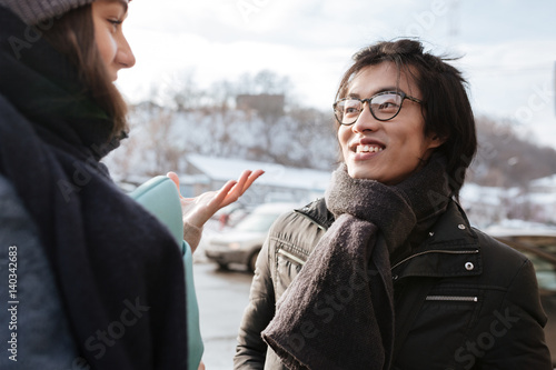 Young asian man with caucasian lady talking with each other