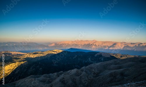 view from the top of Tahtalı Mountain Range during sunrise on sea and valley, Turkey, Kemer © VarnakovR