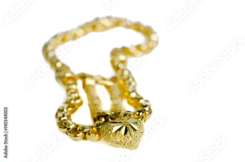 Gold necklace 96.5 percent Thai gold grade with gold heart pendant isolated on red flannel cloth background