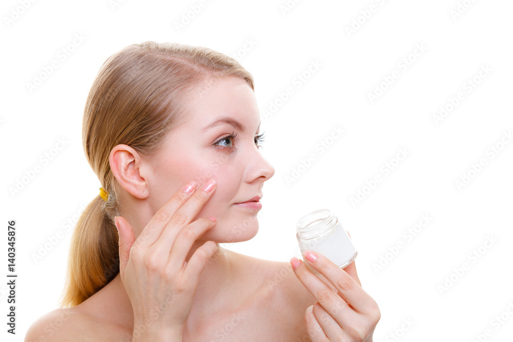 Woman applying face cream with her finger Woman applying face cream with her finger