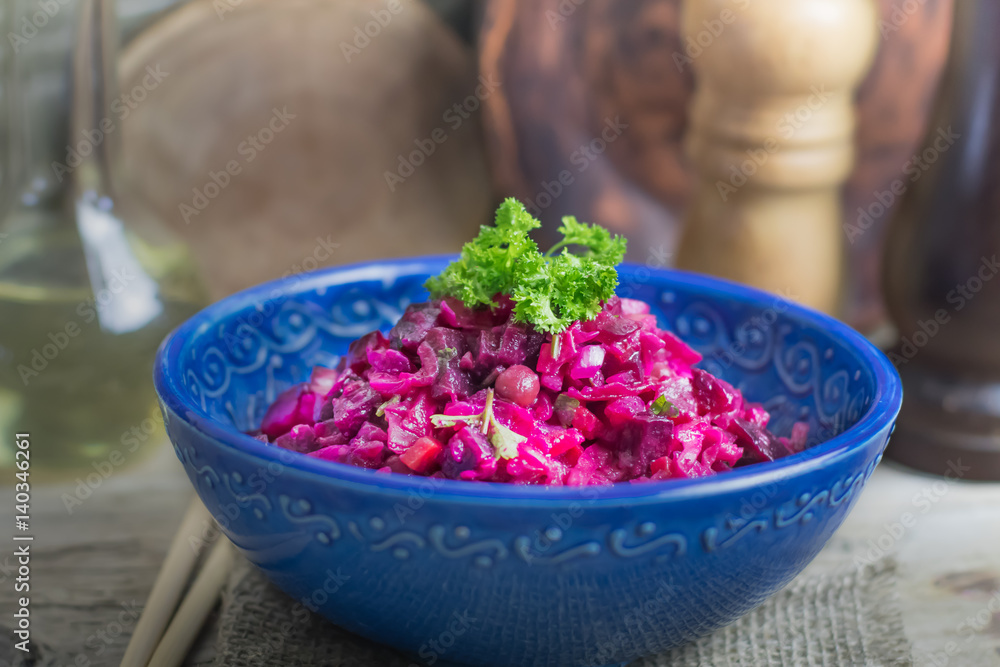 Vinaigrette vegan nutritional vegetarian salad with boiled vegetables in blue ceramic bowl on wooden rustic table. Traditional russian cuisine Vinaigrette vegan nutritional vegetarian salad with boiled vegetables in blue ceramic bowl on wooden rustic table. Traditional russian cuisine