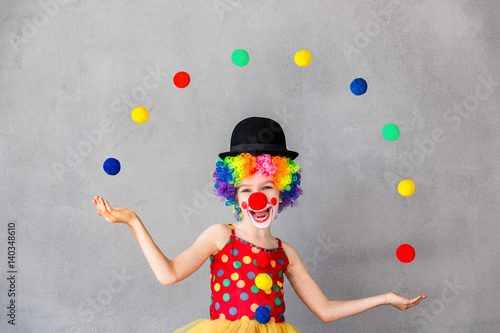 Funny kid clown playing indoor photo