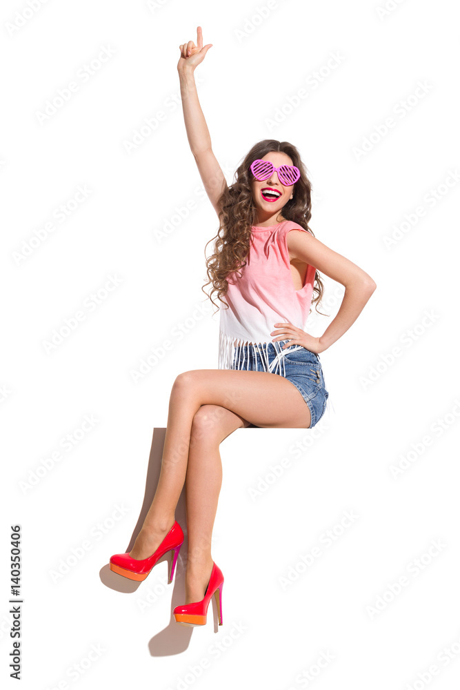 Happy Woman In Pink Sunglasses Sitting And Pointing Happy Woman In Pink Sunglasses Sitting And Pointing