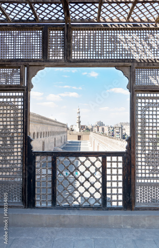 Passage surrounding the Mosque of Ibn Tulun framed by interleaved wooden perforated wall (Mashrabiya), Medieval Cairo, Egypt photo