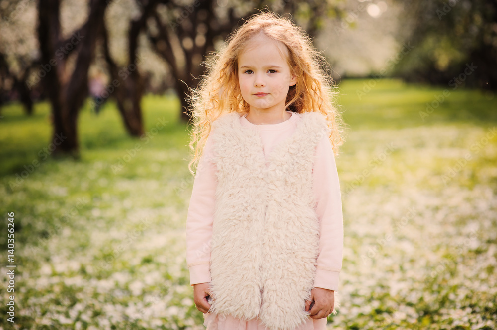spring portrait of beautiful dreamy curly 5 years old child girl walking in blooming garden spring portrait of beautiful dreamy curly 5 years old child girl walking in blooming garden