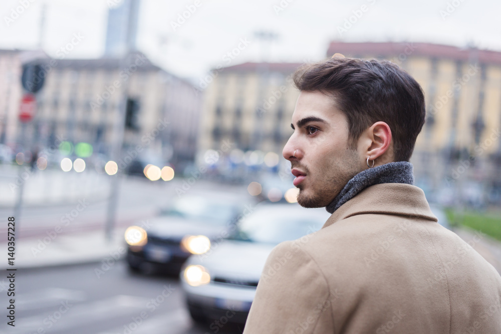Naklejka premium Beautiful young man posing in an urban context