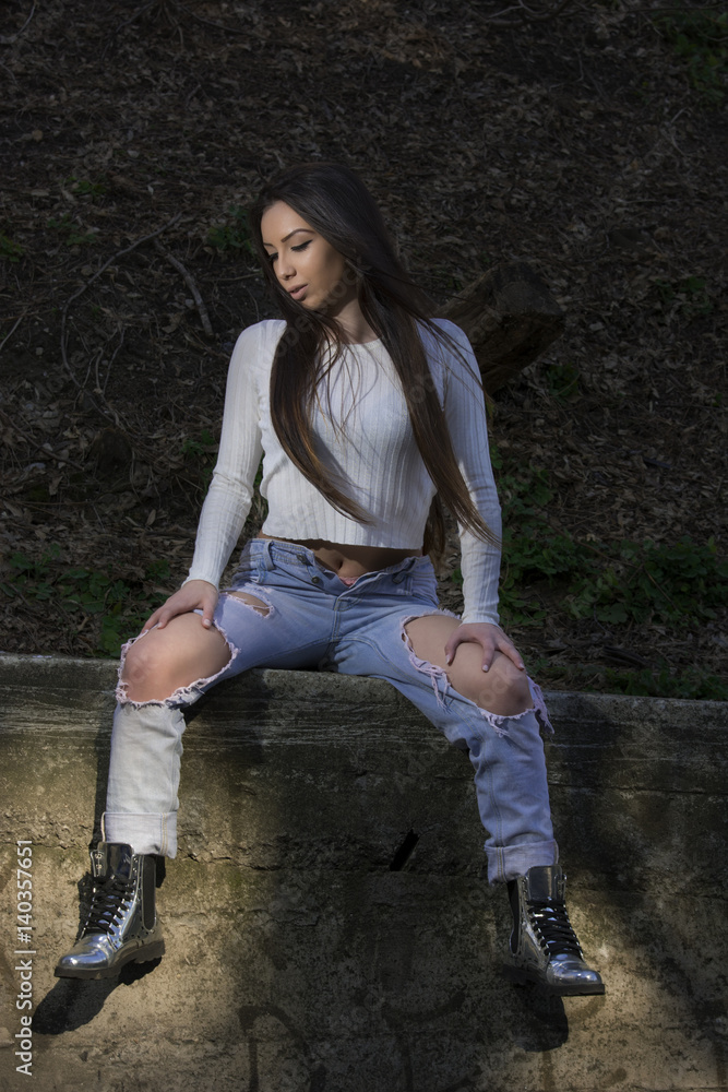 Young woman with white shirt and ripped jeans Young woman with white shirt and ripped jeans