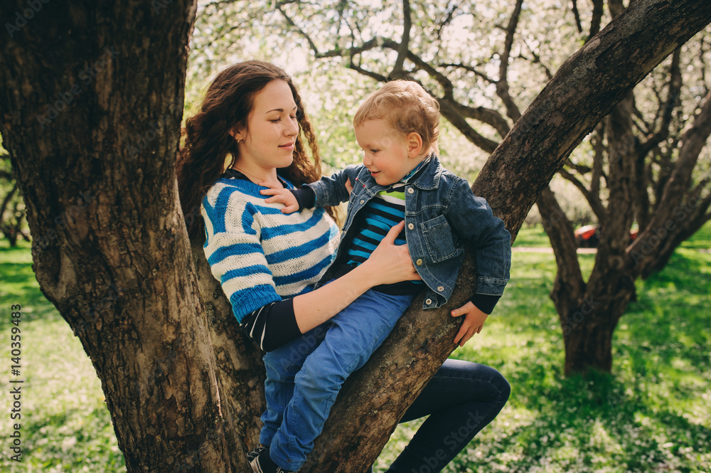 happy young mother and toddler son walking together outdoor and playing, candid lifestyle shot happy young mother and toddler son walking together outdoor and playing, candid lifestyle shot