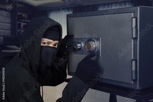 Burglar opening safe-deposit box