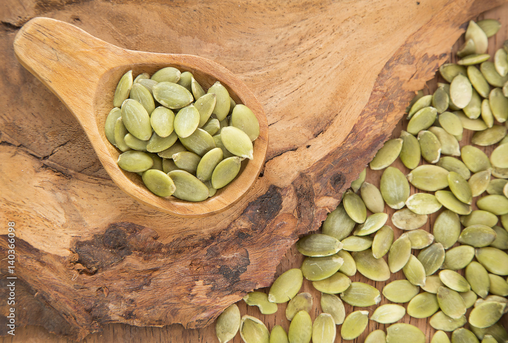 Pumpkin seeds on the wooden background Pumpkin seeds on the wooden background