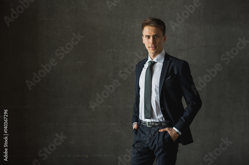 Handsome businessman in formal suit on gray background