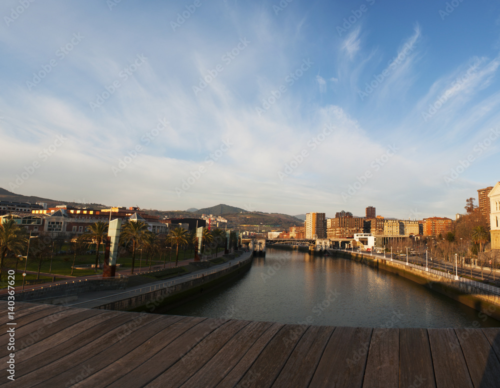 Spagna, 28/01/2017: lo skyline di Bilbao subito dopo l'alba visto dal ponte di legno Pedro Arrupe