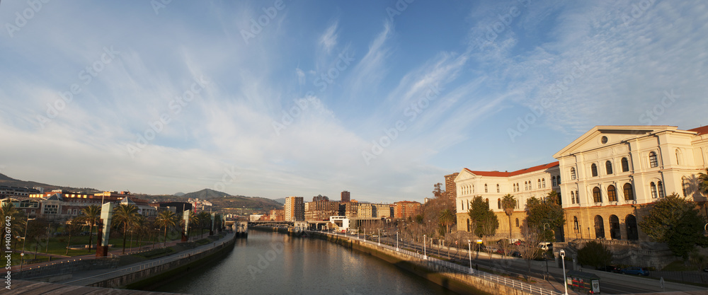 Spagna, 28/01/2017: lo skyline di Bilbao e l'Università di Deusto subito dopo l'alba visti dal ponte di legno Pedro Arrupe