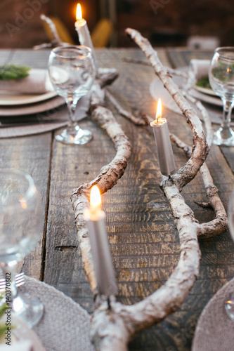 Table served for Christmas dinner with candles and branches