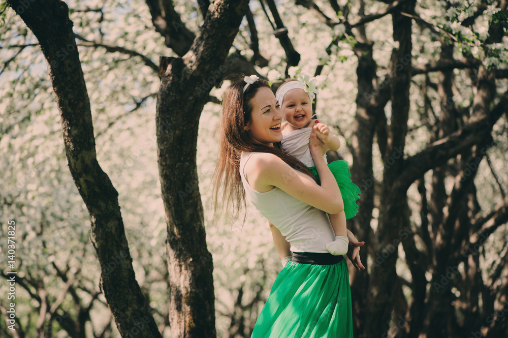 spring portrait of mother and baby daughter playing outdoor in matching outfit - long skirts and shirts. Happy family enjoyng vacation spring portrait of mother and baby daughter playing outdoor in matching outfit - long skirts and shirts. Happy family enjoyng vacation