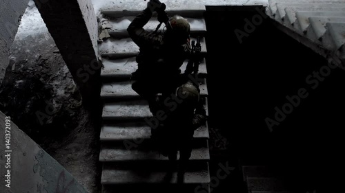 Military men with arms defend the building and go up the stairs