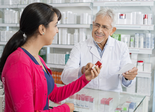 Senior Chemist And Woman With Prescription In Pharmacy