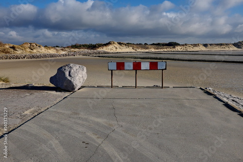 Fin de la route. Route barrée par une barrière et un rocher.