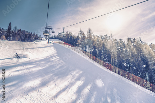Sunny day on steep ski slope, winter landscape. Vintage colors