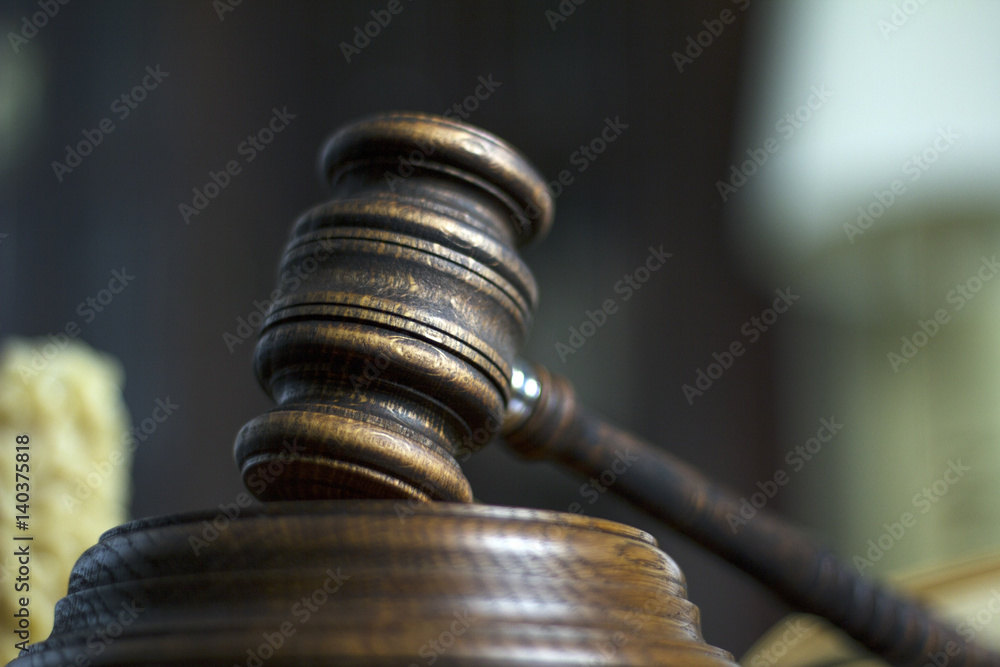 Law theme, mallet of the judge, court gavel wooden rustic desk, handcuffs, candle and books Law theme, mallet of the judge, court gavel wooden rustic desk, handcuffs, candle and books