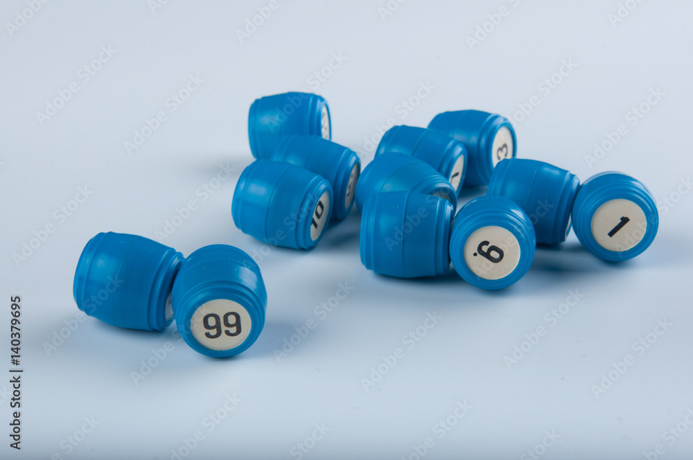 Blue plastic kegs for lotto game with numbers lay on white background Blue plastic kegs for lotto game with numbers lay on white background