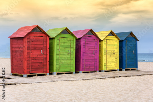 Colorful beach huts on sandy beach © Lux Blue