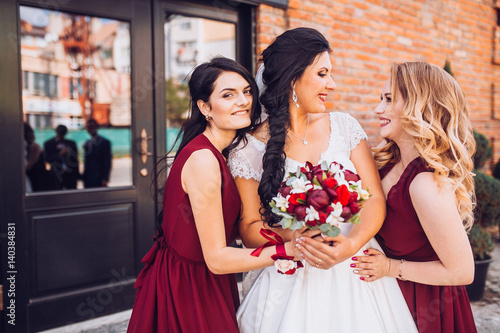 Laughing bride and bridesmaids tell funny stories 