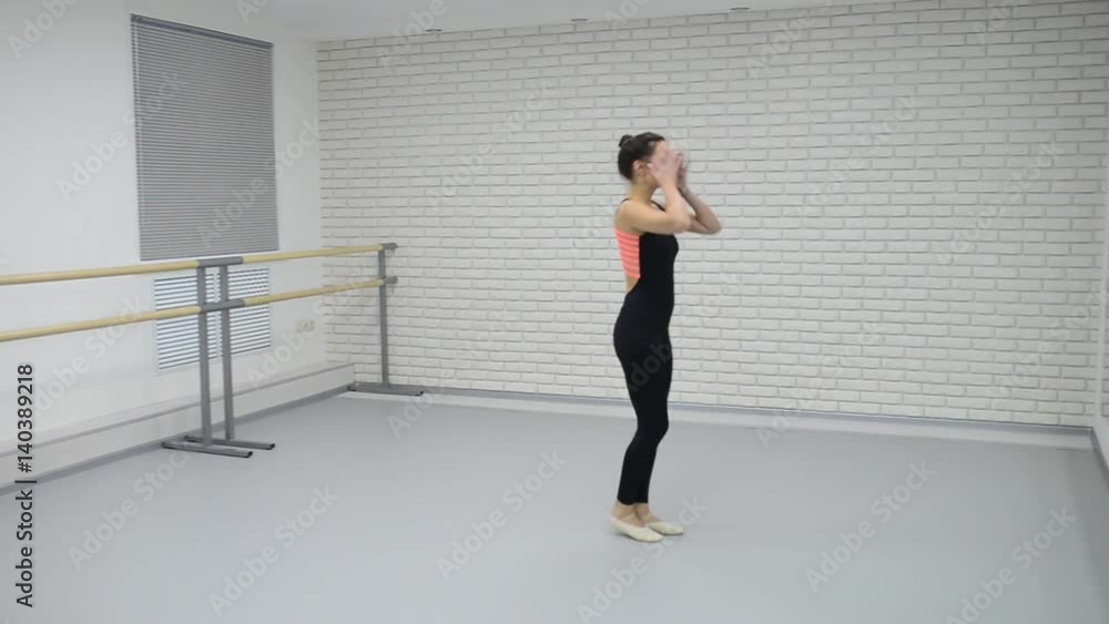 Beautiful woman in black bodysuit enter into dance studio and start dancing ballet looking at mirror Beautiful woman in black bodysuit enter into dance studio and start dancing ballet looking at mirror