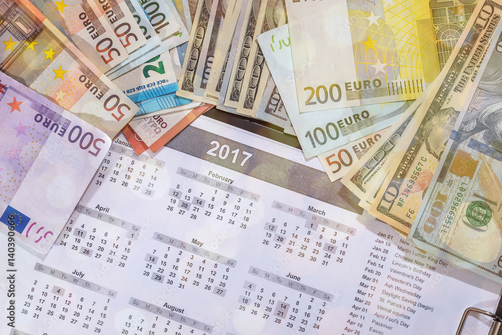 euro and dollar bills, calculator, ink pen and coin money on calendar background euro and dollar bills, calculator, ink pen and coin money on calendar background