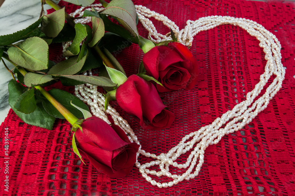 Fototapeta premium Three Red Roses and Pearls in the sharpe of a heart