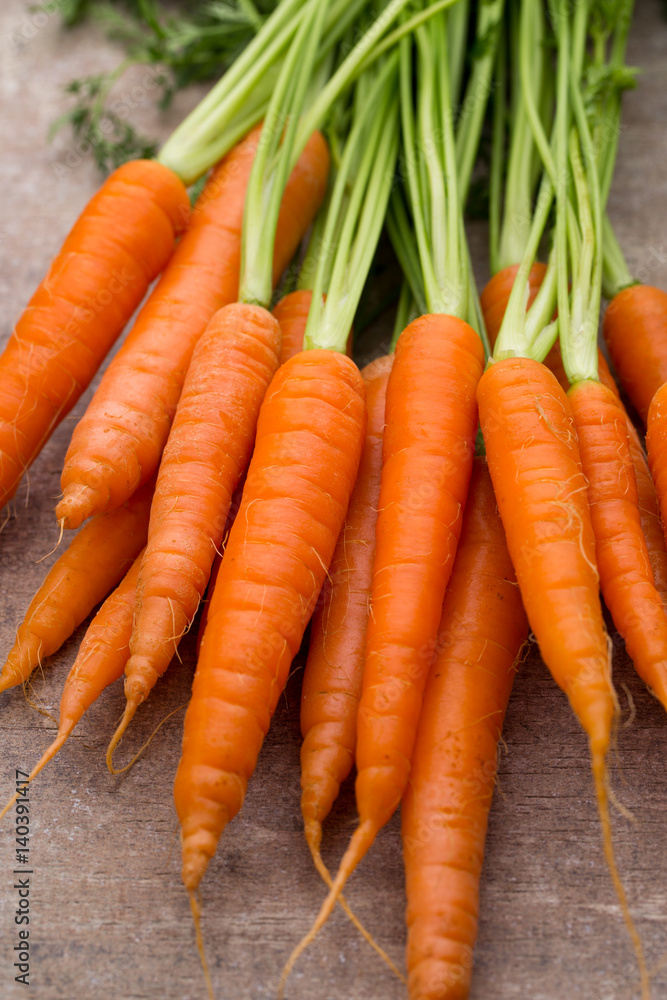 Fresh and sweet carrot on a grey wooden table. Fresh and sweet carrot on a grey wooden table.