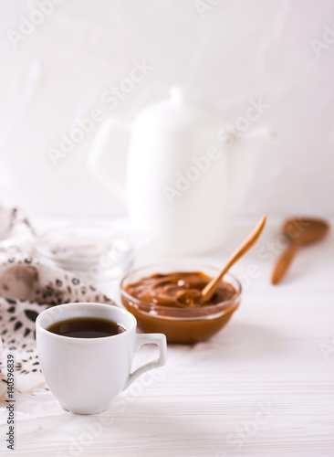 Bowl of homemade melted caramel sauce and coffee