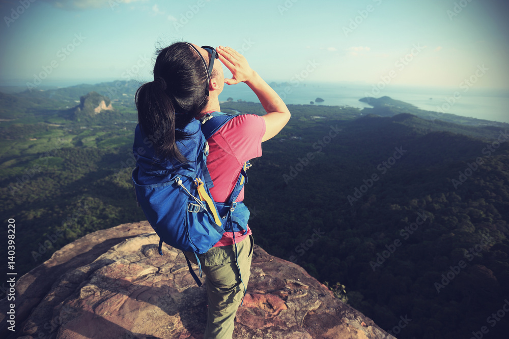successful woman hiker shouting hiking on mountain peak