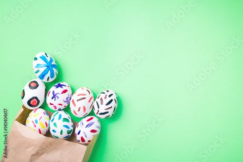 Easter eggs in a paper bag. Green background. Easter ideas. Easter eggs. Space for text.