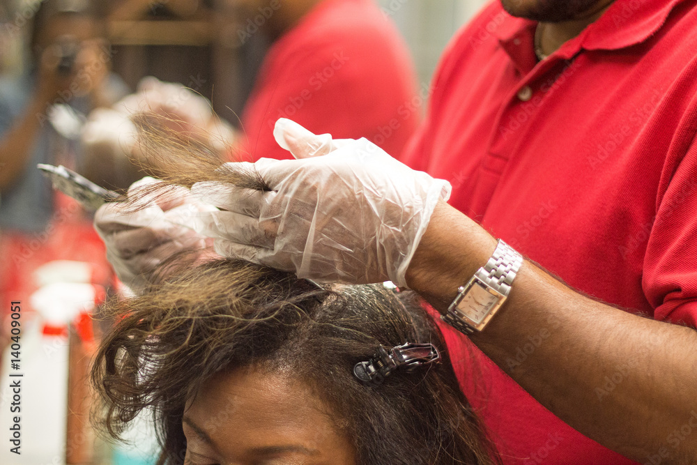 Black male hairstylist applying highlights to Black woman with relaxed hair  Stock Photo | Adobe Stock