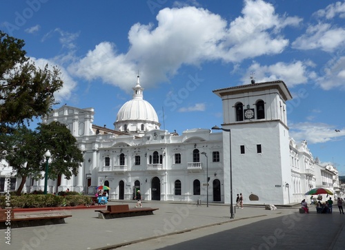 A blue sky day above the beautiful large white Torre del Reloj in the central plaza of Popayan  photo