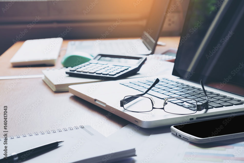 Eyeglasses on laptop keyboard with headphones and diary on wooden table Eyeglasses on laptop keyboard with headphones and diary on wooden table