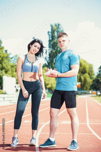 Girl on track with her personal trainer.