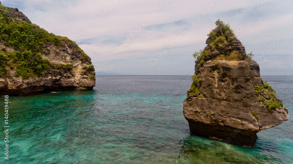 Aerial view of a cliff in the sea on the Suwehan beach. Nusa Penida, Indonesia.